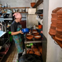 A cook prepares food at the "Rico desde Casa" home-delivery private restaurant in Havana, on June 5, 2023. SMEs (small and medium-sized enterprises), approved only in 2021 in Cuba, are flourishing, displacing the sordid state-owned businesses that are becoming emptier by the day. Authorities decided in 2021 to accelerate the economic opening in the midst of the worst economic crisis in three decades, with shortages of food and medicine, derived from the pandemic and the tightening of Washington's sanctions against the island nation. (Photo by Yamil LAGE / AFP) (Photo by YAMIL LAGE/AFP via Getty Images)